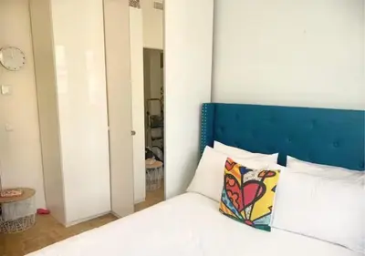 a bedroom with a bed with a blue headboard at 2Bed 2Bath Sea View Promenade Bright & Spacious! BRAVOSTAYSRIVERIA in Nice