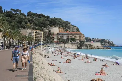 a group of people on a beach near the ocean at Downtown in Nice