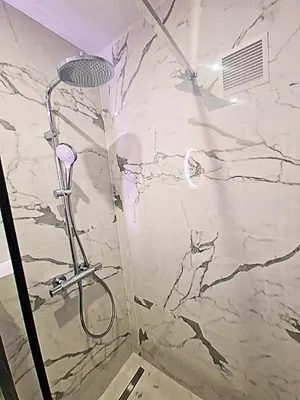 a shower in a bathroom with a marble wall at Côte d'Azur Oasis Suites in Nice