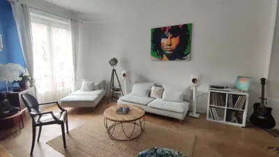 a living room with a couch and a table at Spacieux 4 pièces de type bourgeois Art-déco in Nice