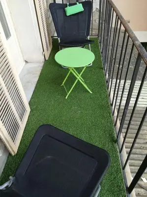 a green table and a chair on a balcony at Spacieux 4 pièces de type bourgeois Art-déco in Nice