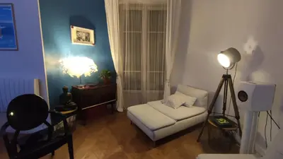 a living room with a white couch and a lamp at Spacieux 4 pièces de type bourgeois Art-déco in Nice