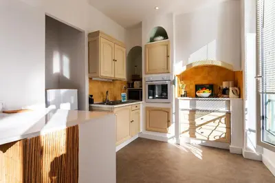 a kitchen with white cabinets and a staircase in it at LE PROVENCE AP4389 By Riviera Holiday Homes in Villefranche-sur-Mer