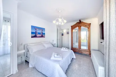 a white bedroom with a bed and a chandelier at FAMILY APARTMENT SEA VIEW in Nice