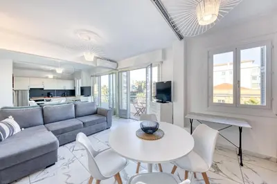 a living room with a couch and a table and chairs at FAMILY APARTMENT SEA VIEW in Nice
