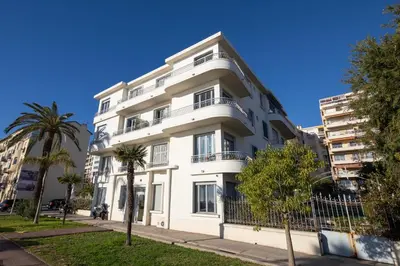 a white building with trees in front of it at FAMILY APARTMENT SEA VIEW in Nice