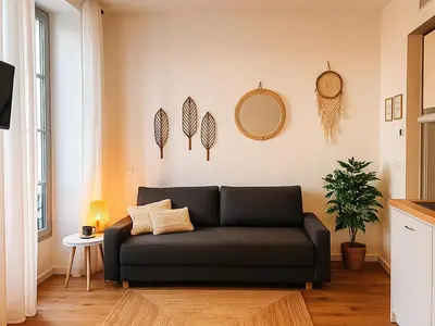 a living room with a black couch and a mirror at Modern apartment with AC near Old Nice & Beach in Nice