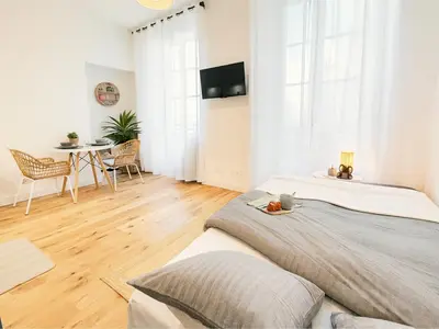 a bedroom with a large bed and a table at Modern apartment with AC near Old Nice & Beach in Nice