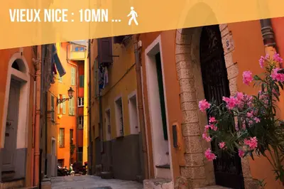 an alley in an old town with pink flowers at Appartements Nice Centre Proche Mer Carré d'Or in Nice