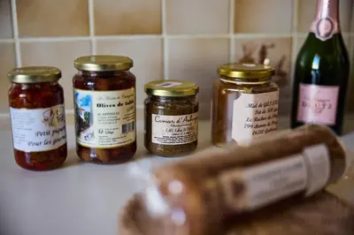 four jars of jam sitting on a counter next to a bottle of wine at Appartements Nice Centre Proche Mer Carré d'Or in Nice