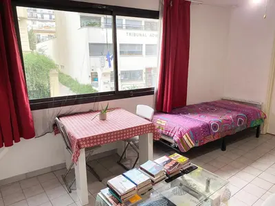 a room with a table and a bed and a window at bellissimo appartamento in Nice