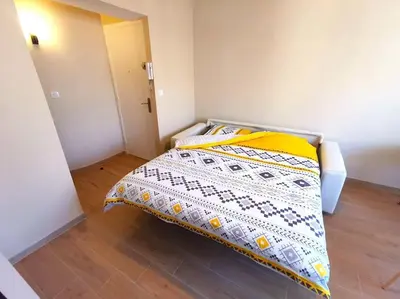 a bedroom with a bed with a yellow and white blanket at Studio cosy - Proche mer et gare in Nice