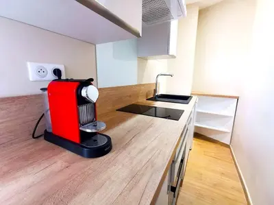 a kitchen with a red appliance on top of a counter at Studio cosy - Proche mer et gare in Nice