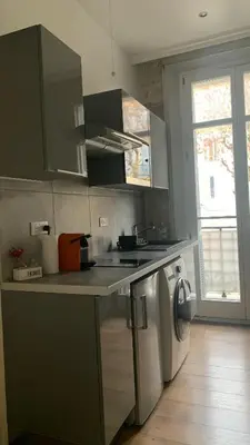 a kitchen with a sink and a washing machine at Studio meublé in Nice