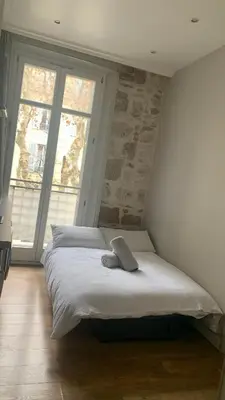 a bedroom with a large bed with two windows at Studio meublé in Nice