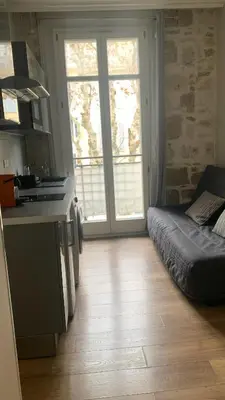 a kitchen with a large window and a couch at Studio meublé in Nice