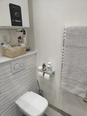a white bathroom with a toilet and a towel at Studio meublé in Nice