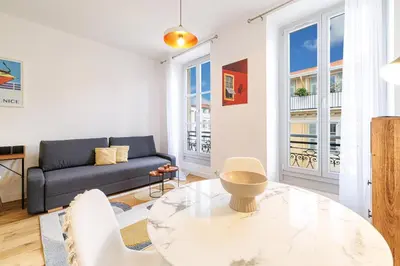 a living room with a couch and a table at Charming City Center Studio 406 in Nice