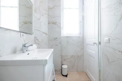 a white bathroom with a sink and a mirror at Lovely 2 Bdr Nice Harbor in Nice
