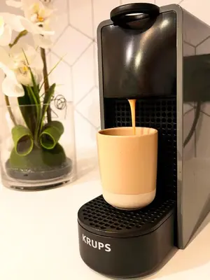 a cup of coffee is being poured into a coffee machine at Apartment Malaussena - Reception 24&7 - Center Libération in Nice