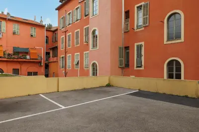a parking lot in front of a large building at NICE RENTING - PHILIBERT - Elegant Spacious Quiet Near the Port Free Parking in Nice