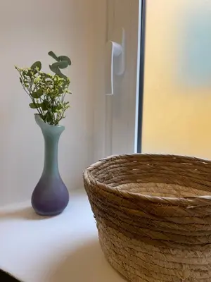 a vase with flowers in it next to a basket at 2 pièces dans le Vieux Nice - à 3 min de la mer et du célèbre cours Saleya in Nice