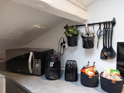 a kitchen counter with a microwave and utensils at Loft Cosy NICE centre ville in Nice