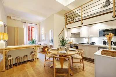 a kitchen and living room with a table and chairs at Elegant flat with AC, heart of old Nice, Walking to the Beach! in Nice