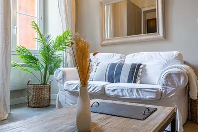 a living room with a white couch and a table at Elegant flat with AC, heart of old Nice, Walking to the Beach! in Nice