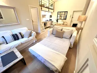 a living room with two white couches and a kitchen at Elegant flat with AC, heart of old Nice, Walking to the Beach! in Nice