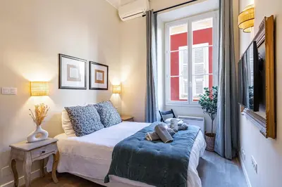 a small bedroom with a bed and a window at Elegant flat with AC, heart of old Nice, Walking to the Beach! in Nice