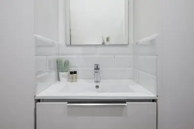 a white bedroom with a white bed and a window at Pertinax Cosy 2 pièces au coeur du centre ville de Nice AC in Nice