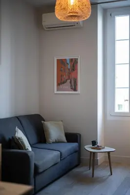 a living room with a table and a couch at Saint Jean Baptiste, studio pour 2 personnes Garibaldi, Coulée Verte in Nice