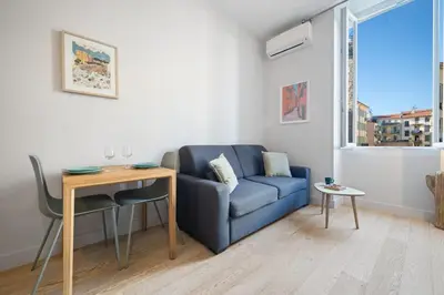 a living room with a blue couch and a window at Saint Jean Baptiste, studio pour 2 personnes Garibaldi, Coulée Verte in Nice