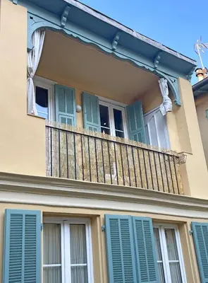 a balcony on a house with blue shutters at Casa Marguerite, studio atypique in Nice