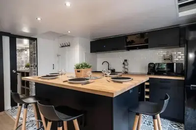 a kitchen with a large island with bar stools at Appartement avec mezzanine in Nice