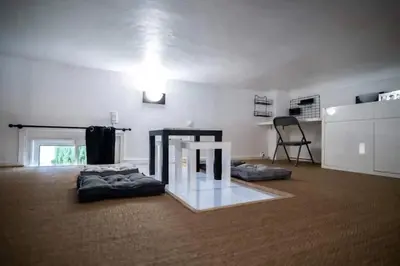 a living room with a table and some pillows at Appartement avec mezzanine in Nice