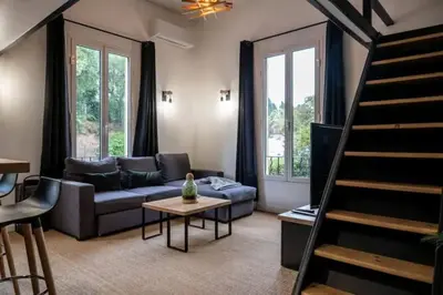 a living room with a couch and a table at Appartement avec mezzanine in Nice