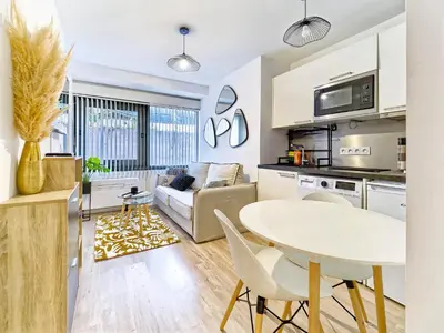 a kitchen and living room with a white table and chairs at Magnifique T2 neuf - résidence neuf- Hyper central in Nice