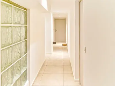 a hallway with white walls and a tile floor at Magnifique T2 neuf - résidence neuf- Hyper central in Nice