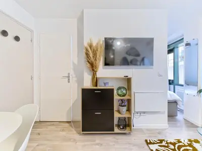 a white living room with a tv on a wall at Magnifique T2 neuf - résidence neuf- Hyper central in Nice