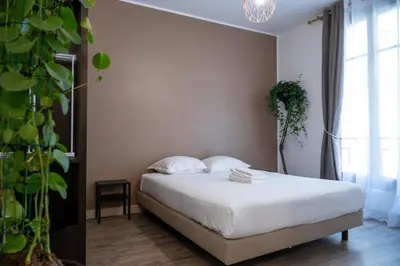 a bedroom with a bed with white sheets and a plant at GuestReady - A peaceful stay near the marina in Nice