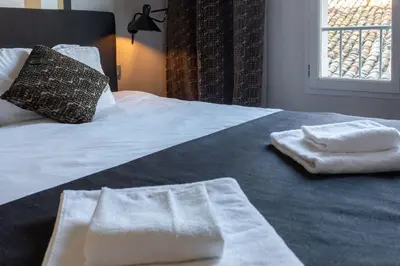 a bed with two towels sitting on top of it at #39 Old Town suite 3 BDR AC Balcony 5mins Walk to Sea in Nice