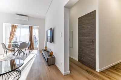 a living room with a wooden door and a table at Les Grands Cèdres - Wifi, AC, Parking in Nice