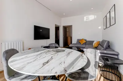 a living room with a table and a couch at Les Grands Cèdres - Wifi, AC, Parking in Nice