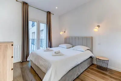 a bedroom with a large bed and a large window at Les Grands Cèdres - Wifi, AC, Parking in Nice