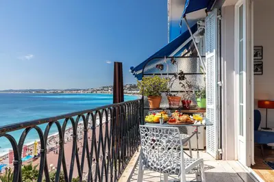 a balcony with a table of food and the ocean at MY CASA - ETAT UNIS 93 INDIGO - Amazing Sea View Aprt with AC in Nice