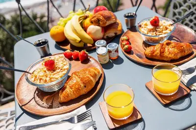 a table topped with plates of breakfast foods and orange juice at MY CASA - ETAT UNIS 93 INDIGO - Amazing Sea View Aprt with AC in Nice