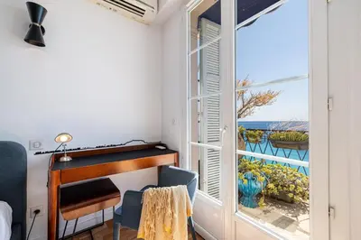 a room with a desk and a window with a view of the ocean at MY CASA - ETAT UNIS 93 INDIGO - Amazing Sea View Aprt with AC in Nice