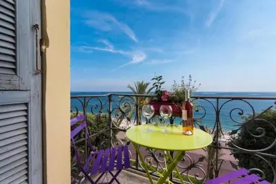 a table and chairs on a balcony with the ocean at MY CASA - ETATS UNIS 894 - Stunning on Sea Front w AC in Nice
